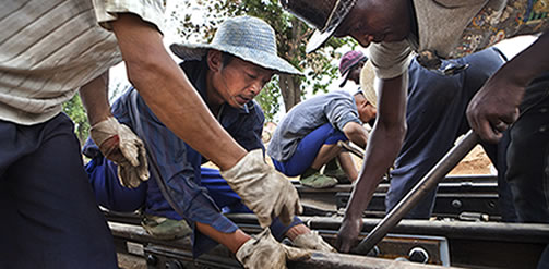 Chinese and African workers on the construction site of a station and railway which is part of a devlopment aid project by China in Angola in exchange for petroleum. Credit: D. Telemans / Panos