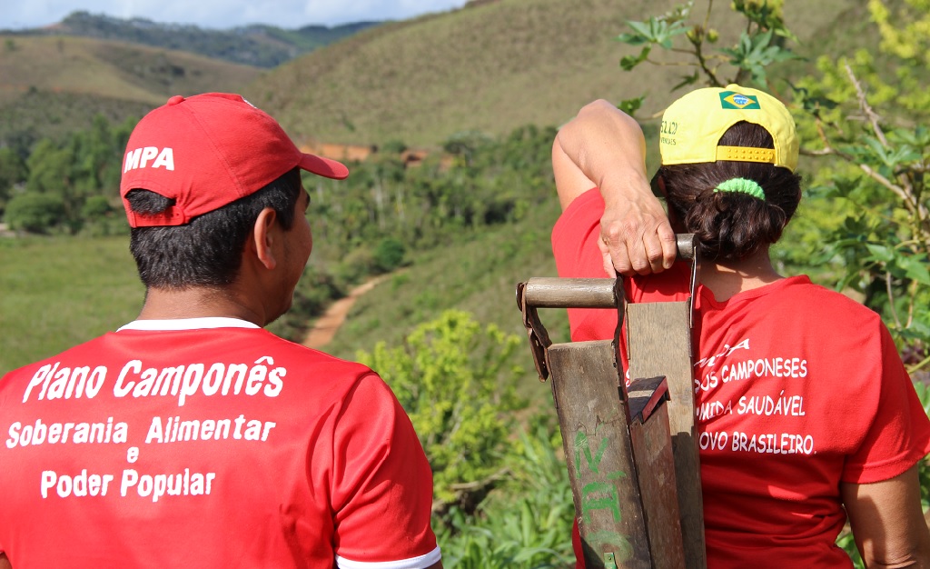 Agro-ecology workers look out over the rural Brazilian landscape.