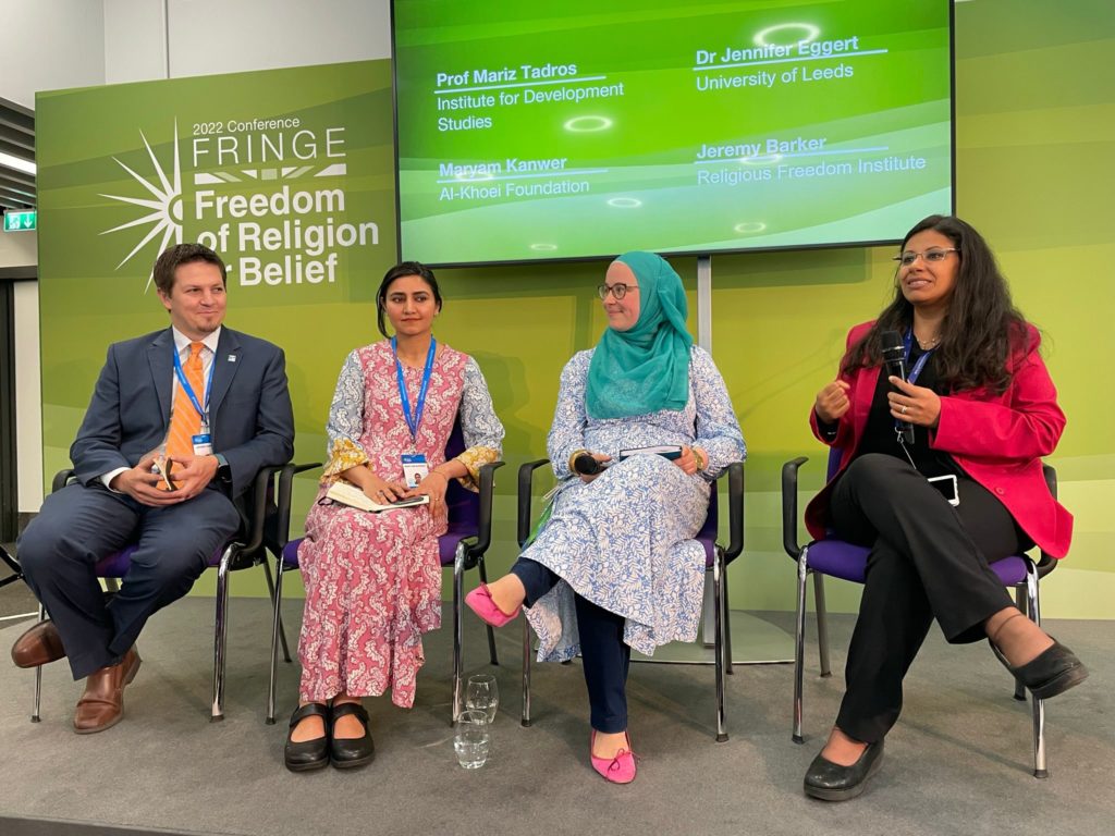 Photograph of one man and three women speaking at an event 