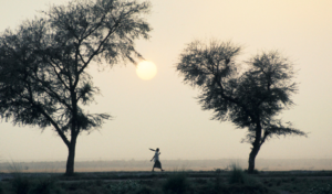 Woman walks across a baron landscape