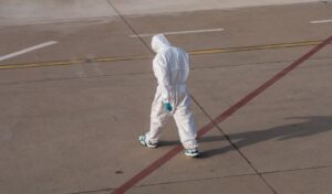 Back of a person in medical suit walking away 