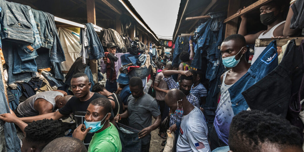 A photo of a group of men in Kantamanto market in Accra, Ghana, which is selling second-hand clothing and shoes.