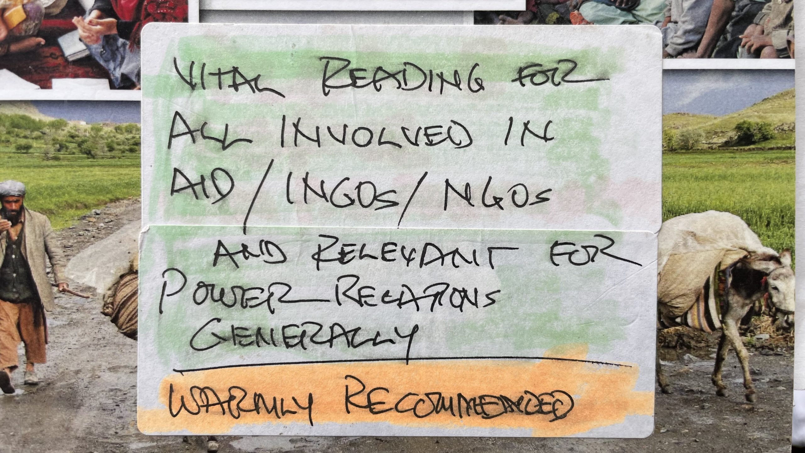 A book with a handwritten note on it. The book title isn't visible but you can see photo of livestock. The note reads "Vital reading for all involved in aid/INGOs/NGOs and relevant for power relations generally. Warmly recommended".