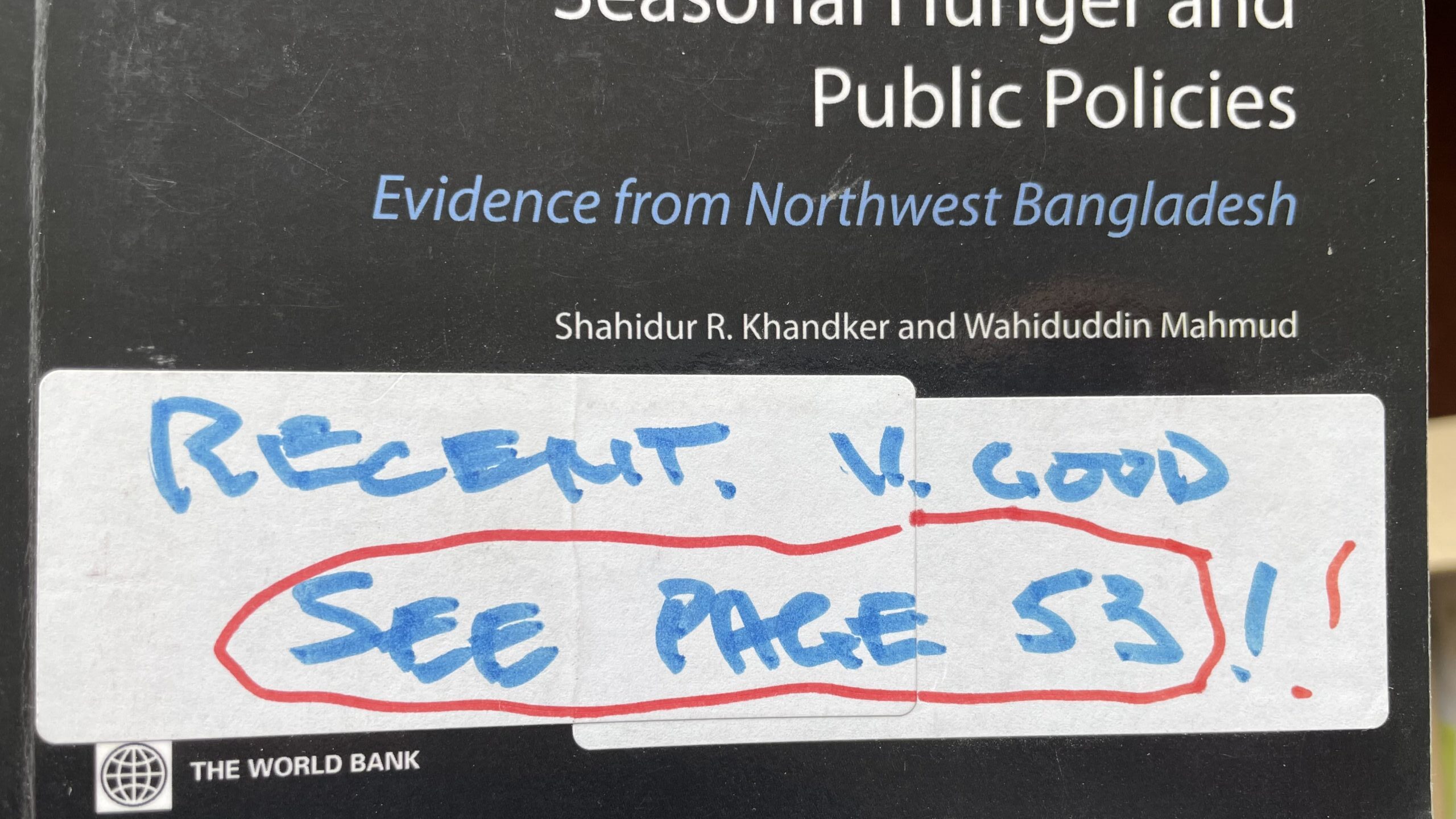 A photo of a book cover with a handwritten note stuck to it. The visible part of the book cover reads "Seasonal hunger and public policies. Evidence from Northwest Bangladesh. Shahidur R. Khandker and Wahiduddin Mahmud. The World Bank. The handwritten note reads "Recent. V. good. See page 53!!"