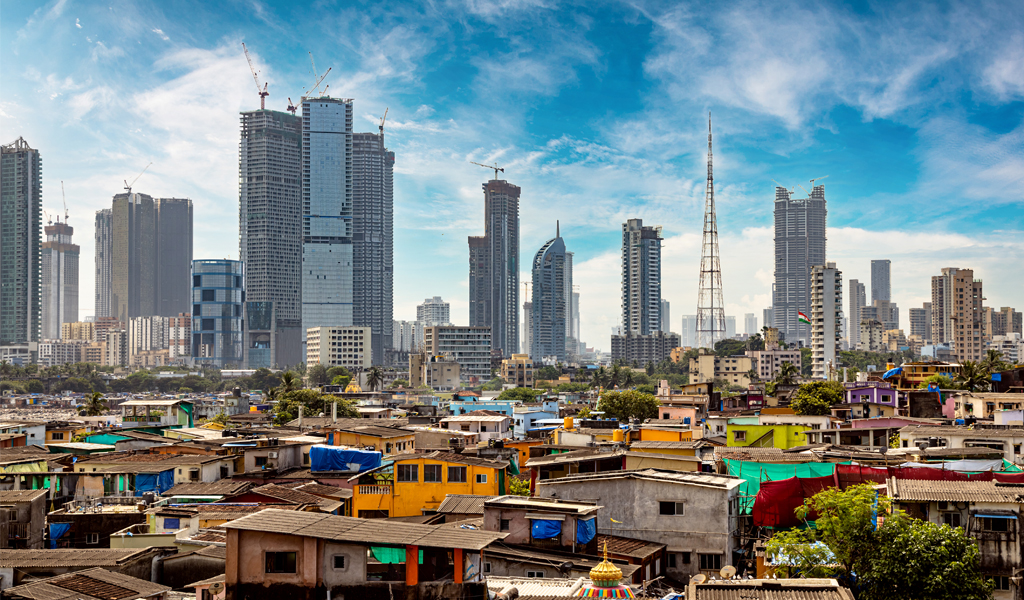 Views of slums on the shores of Mumbai, India against the backdrop of skyscrapers under construction