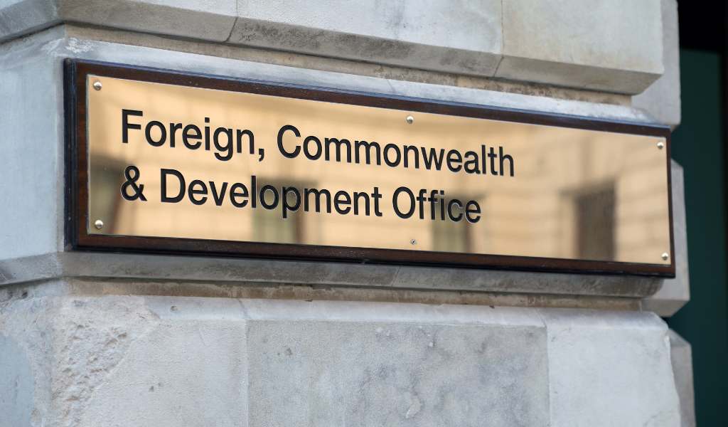 Shiny brass sign on the side of a stone building that reads Foreign, Commonwealth & Development Office.